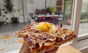 Deliciosa coca de cebolla con huevo frito coronando esta maravilla. Perfecta para un aperitivo o cena rápida.