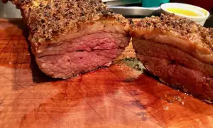 Jugosa picaña a la brasa, cortada en dos, con su capa crujiente y carne rosada. Perfecta para compartir.