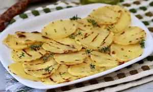 Deliciosas patatas a la plancha, finamente cortadas y con marcas de parrilla, adornadas con ramitas de tomillo fresco.