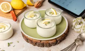 Delicioso mousse de limón Thermomix en vasitos, decorado con rodajas de limón y tomillo.