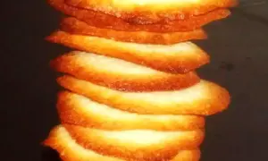 Torre de crujientes galletas de coco, doradas y apetitosas, apiladas unas sobre otras.