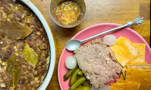 Pate de campaña casero, servido con pepinillos, cebollitas y galletas saladas. Un festín rústico.