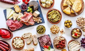 Gran variedad de aperitivos baratos para mucha gente: embutidos, quesos, aceitunas, frutos secos, pimientos, boquerones y tortilla.