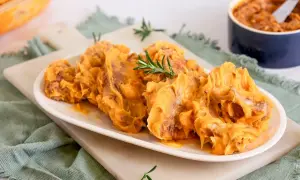 Delicioso lomo en manteca, servido en plato blanco con romero. Un manjar cremoso y apetitoso.