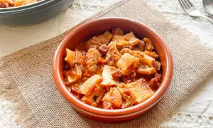 Un cuenco de barro con callos a la vizcaína, un plato tradicional español con trozos de tripa y chorizo en salsa.