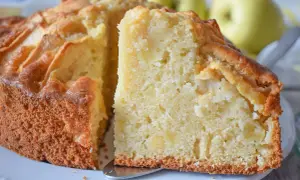 Un trozo de bizcocho de manzana casero, con trozos de fruta visibles en su interior tierno y dorado.