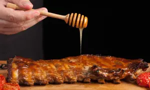 Costillas a la miel jugosas, bañadas con miel dorada de un palito de madera. Un manjar irresistible.