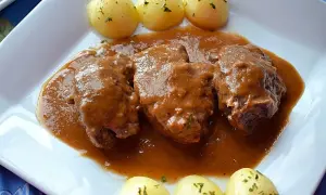 Carrilleras de cerdo en salsa, la receta de la abuela que evoca recuerdos. Servidas con patatas cocidas.