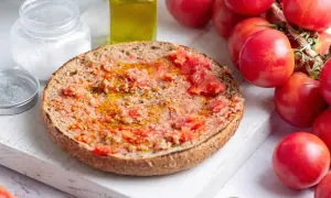 Rebanada de pan tostado con tomate rallado y aceite de oliva, lista para disfrutar de un delicioso pa amb tomàquet.