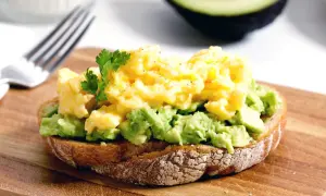 Tostada con aguacate machacado y huevos revueltos, una de las mejores recetas con aguacate.