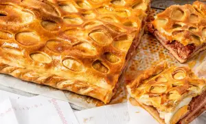 Un delicioso hornazo de Salamanca, con su masa dorada y relleno de carne y huevo duro, listo para ser disfrutado.