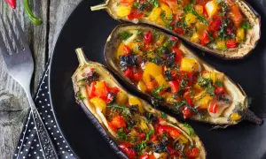 Berenjenas rellenas de verduras, con pimientos rojos y amarillos, hierbas frescas y un toque de aceitunas negras.