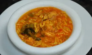 Un plato de gurullos con conejo, un guiso tradicional con pasta corta y trozos de carne de conejo en una salsa rojiza.