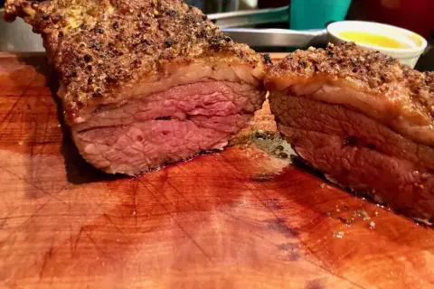 Jugosa picaña a la brasa, cortada en dos, con su capa crujiente y carne rosada. Perfecta para compartir.