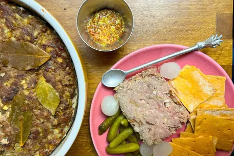 Pate de campaña casero, servido con pepinillos, cebollitas y galletas saladas. Un festín rústico.