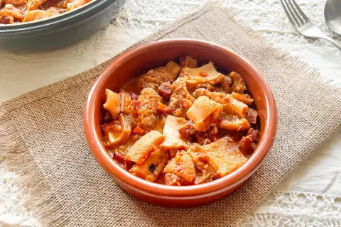 Un cuenco de barro con callos a la vizcaína, un plato tradicional español con trozos de tripa y chorizo en salsa.