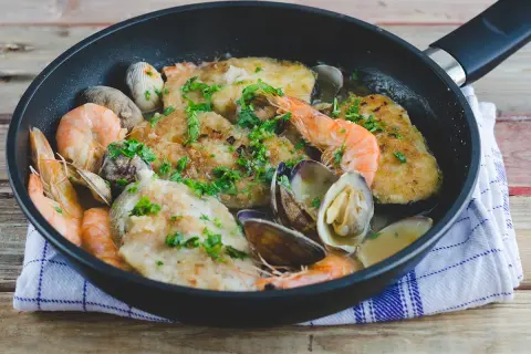 Merluza a la marinera con almejas y gambas, un plato delicioso y fresco, listo para disfrutar.