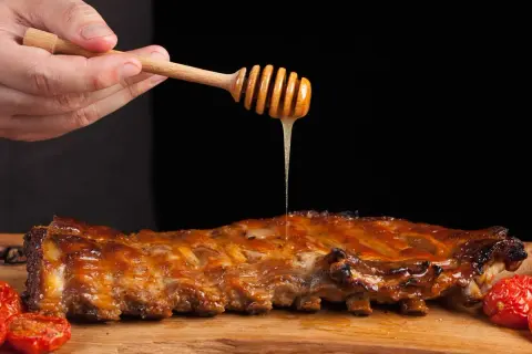 Costillas a la miel jugosas, bañadas con miel dorada de un palito de madera. Un manjar irresistible.