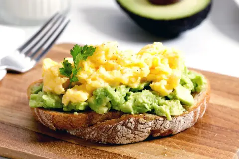 Tostada con aguacate machacado y huevos revueltos, una de las mejores recetas con aguacate.
