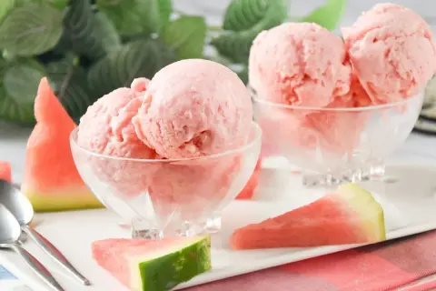 Delicioso helado de sandía casero en copas de cristal, acompañado de trozos de sandía fresca. ¡Un postre refrescante!