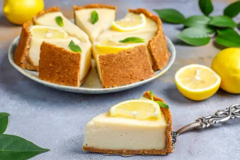Deliciosa tarta de limón sin horno, cremosa y refrescante, decorada con rodajas de limón y hojas de menta.