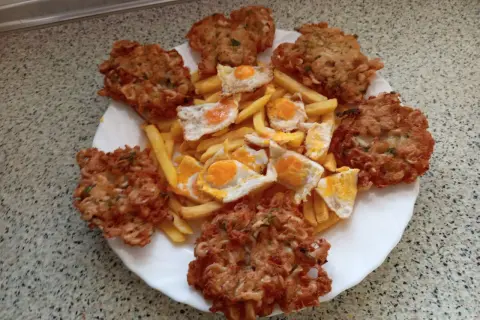 Tortillas de camarón crujientes y doradas, acompañadas de papas fritas y huevos estrellados. Un festín para los sentidos.