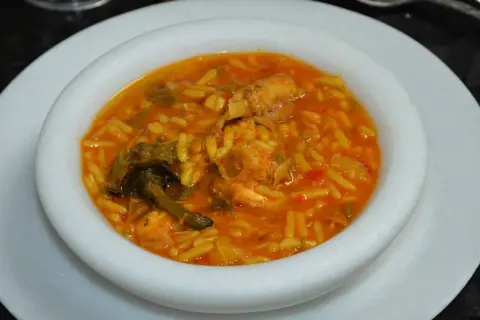 Un plato de gurullos con conejo, un guiso tradicional con pasta corta y trozos de carne de conejo en una salsa rojiza.