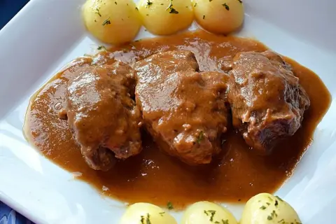 Carrilleras de ternera estofadas en salsa, acompañadas de patatas cocidas con perejil picado. Un plato casero que huele a tradición.