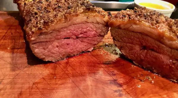 Jugosa picaña a la brasa, cortada en dos, con su capa crujiente y carne rosada. Perfecta para compartir.