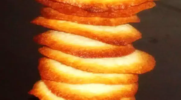Torre de crujientes galletas de coco, doradas y apetitosas, apiladas unas sobre otras.