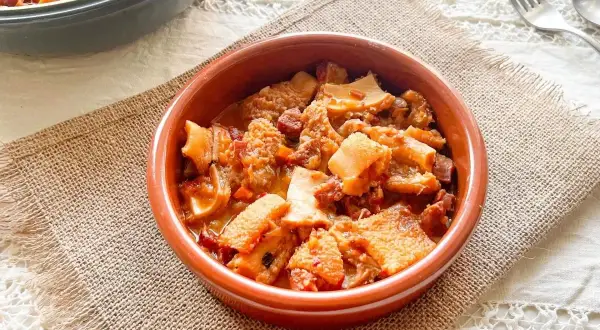 Un cuenco de barro con callos a la vizcaína, un plato tradicional español con trozos de tripa y chorizo en salsa.