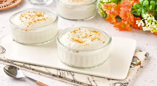 Delicioso mousse de yogur en vasitos de cristal, espolvoreado con canela. Un postre ligero y refrescante.