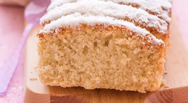 Bizcocho de coco esponjoso, cortado en rebanadas y espolvoreado con coco rallado. ¡Perfecto para acompañar un café!