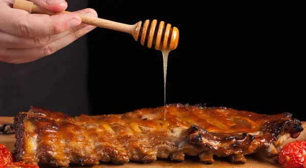 Costillas a la miel jugosas, bañadas con miel dorada de un palito de madera. Un manjar irresistible.
