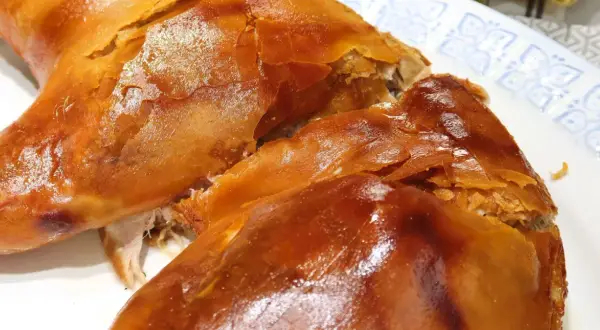 Un crujiente cochinillo al horno, con piel dorada y carne jugosa, listo para ser disfrutado en una celebración.