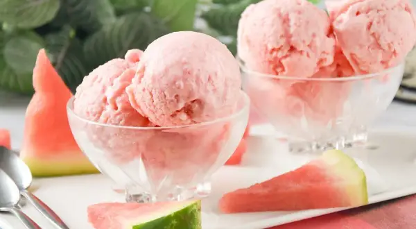 Delicioso helado de sandía casero en copas de cristal, acompañado de trozos de sandía fresca. ¡Un postre refrescante!