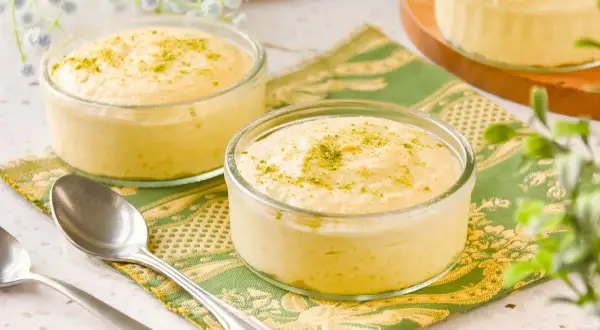 Delicioso mousse de mango en copas de cristal, espolvoreado con ralladura verde.