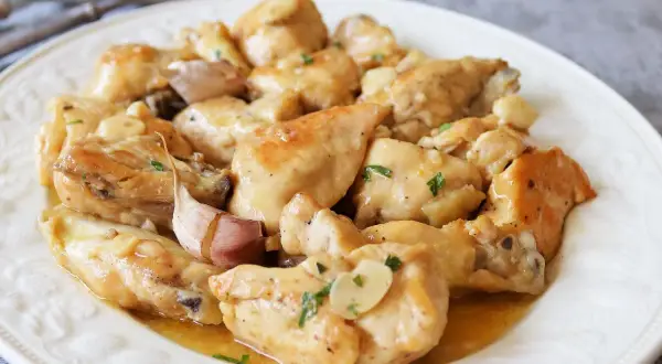 Saborea el pollo al limón receta de la abuela, jugoso y con un toque de ajo, servido en un plato blanco.