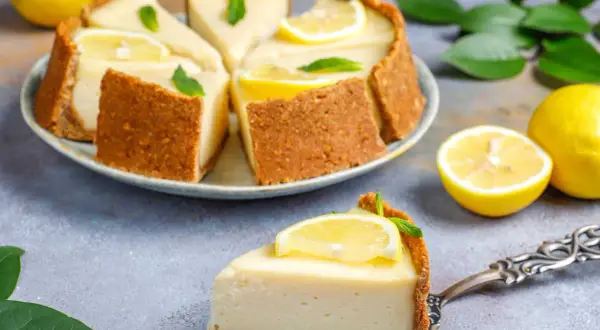 Deliciosa tarta de limón sin horno, cremosa y refrescante, decorada con rodajas de limón y hojas de menta.