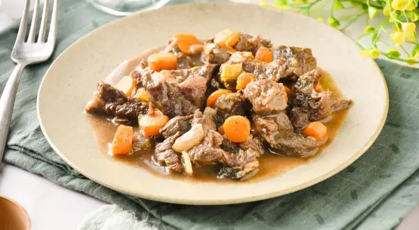 Tierna ternera en salsa con zanahorias y cebolla, un plato reconfortante y sabroso.