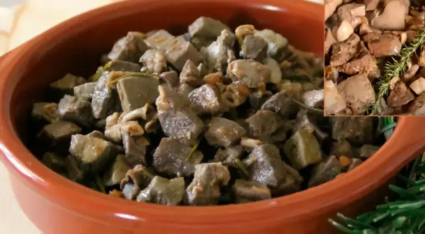 Deliciosa asadura de cordero guisada con hierbas aromáticas, servida en una cazuela de barro.