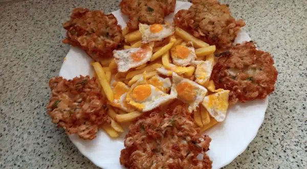 Tortillas de camarón crujientes y doradas, acompañadas de papas fritas y huevos estrellados. Un festín para los sentidos.