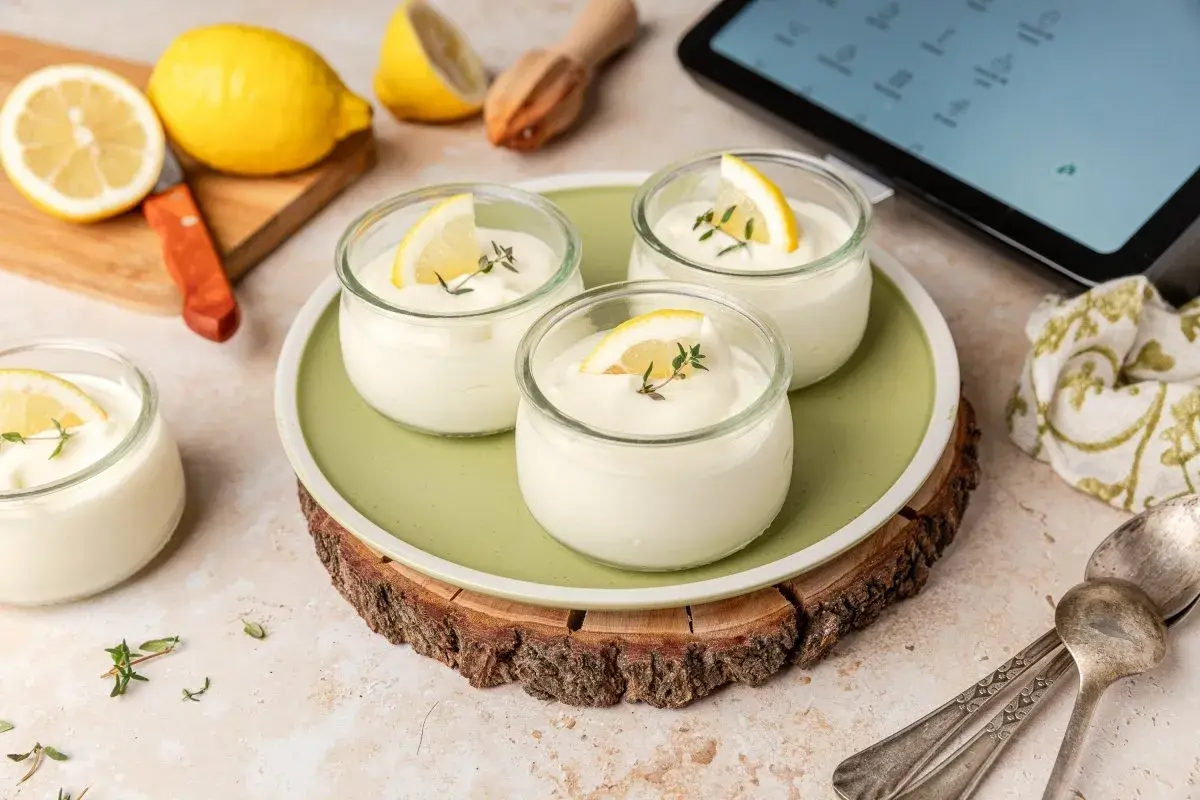 Delicioso mousse de limón Thermomix en vasitos, decorado con rodajas de limón y tomillo.