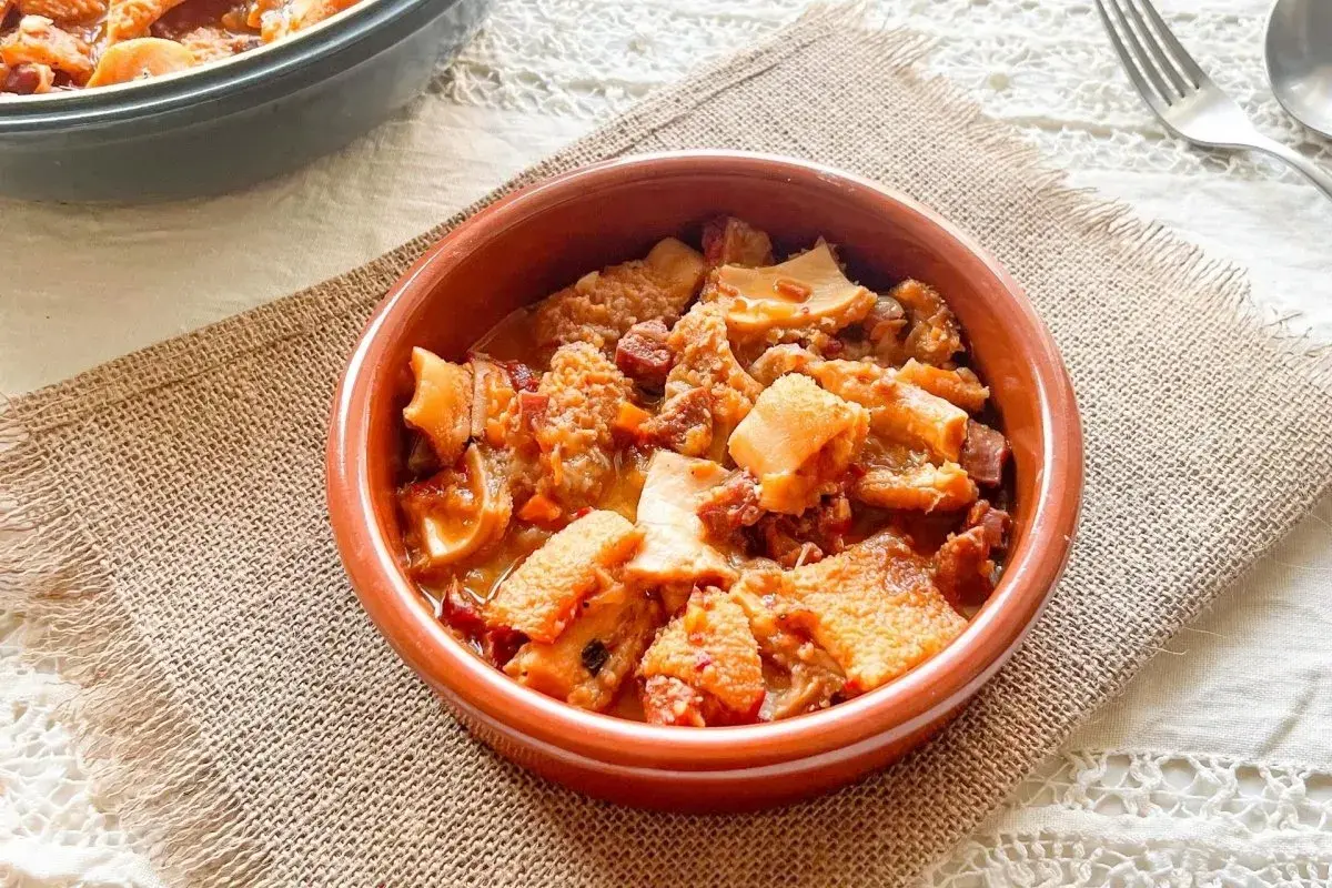 Un cuenco de barro con callos a la vizcaína, un plato tradicional español con trozos de tripa y chorizo en salsa.