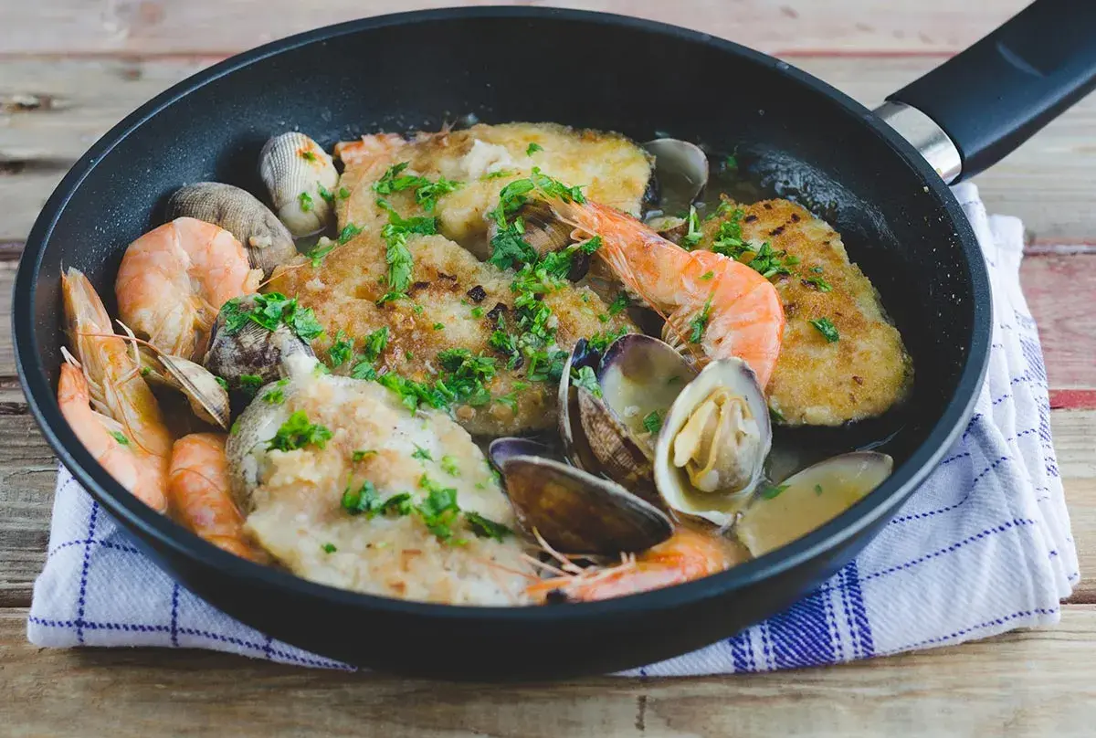 Merluza a la marinera con almejas y gambas, un plato delicioso y fresco, listo para disfrutar.