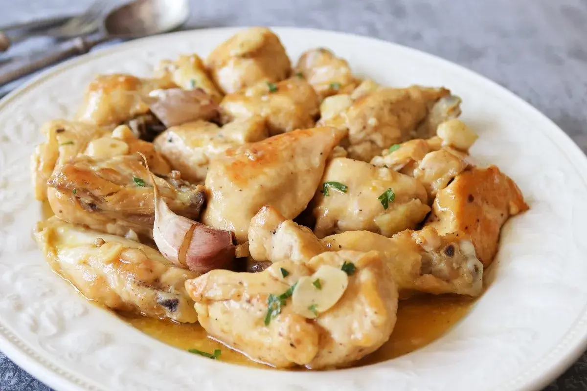 Saborea el pollo al limón receta de la abuela, jugoso y con un toque de ajo, servido en un plato blanco.