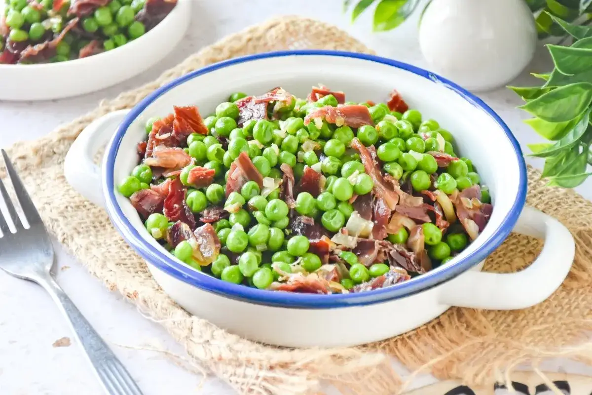 Guisantes con jam&oacute;n, la receta de la abuela que evoca sabores caseros. Un plato sencillo y delicioso.