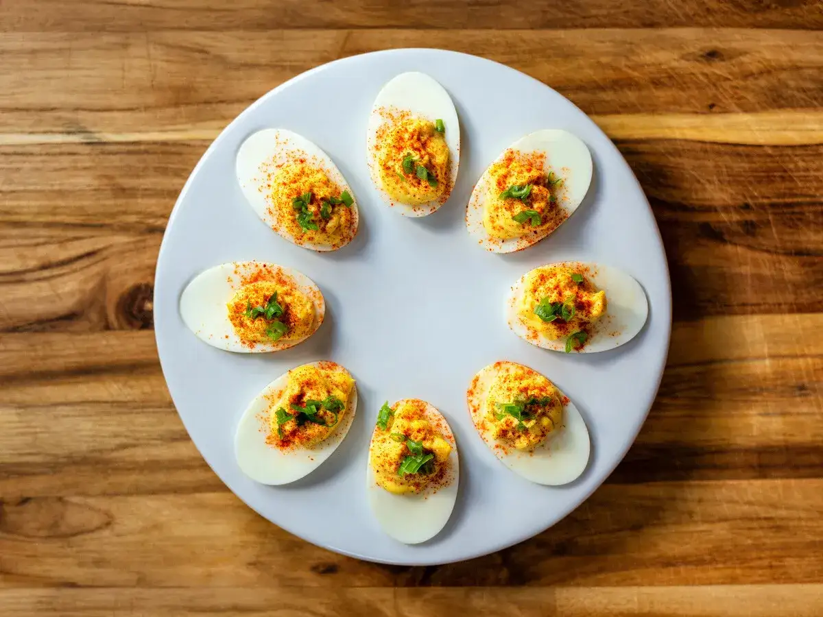 Huevos rellenos perfectos para inspirarte con 10 recetas. Adornados con pimentón y cebollín.