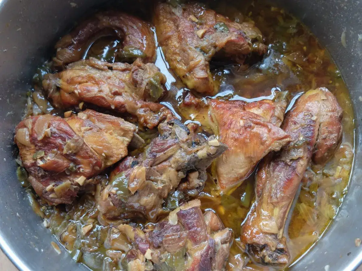 Sabroso pollo de corral guisado en una olla, con trozos dorados y jugosos en una salsa arom&aacute;tica con cebolla y pimientos.