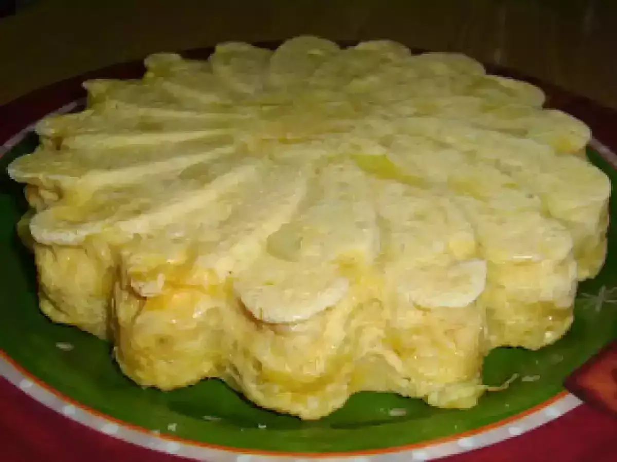 Tortilla francesa en microondas con forma de flor, dorada y esponjosa, servida en un plato verde con borde rojo.